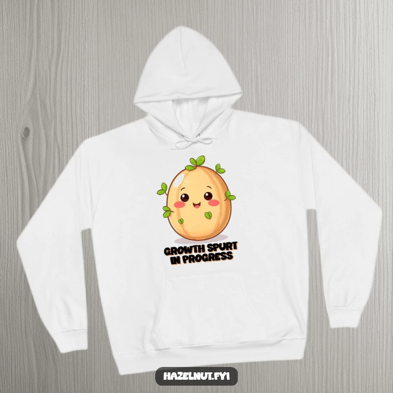 Funny hazelnut character with tiny leaves sprouting, depicted on a warm hoodie, bringing cozy humor and nature vibes.