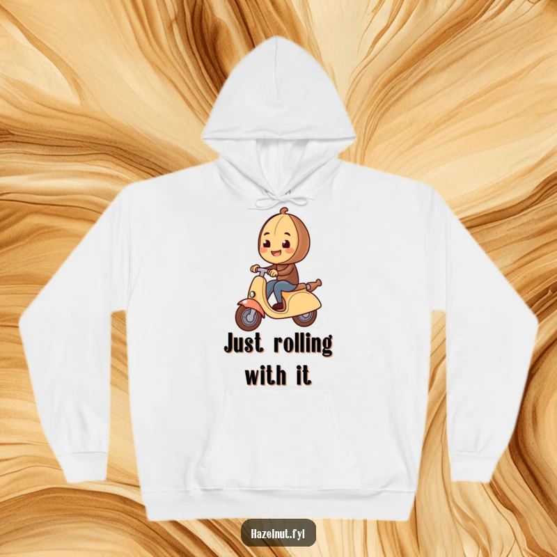 Funny Hazelnut Hoodie shows a cheerful hazelnut cruising on a large rolling pin like a scooter, perfect for cozy laughs.