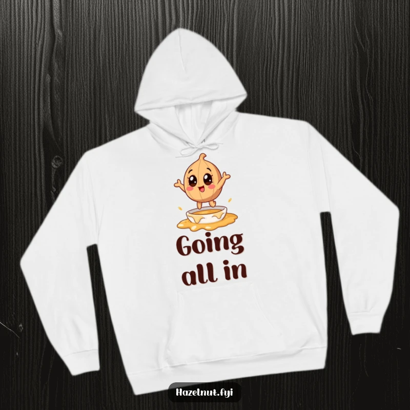 Funny hazelnut character with large eyes, jumping into melting caramel, on a cozy hoodie, a humorous and warm gift.